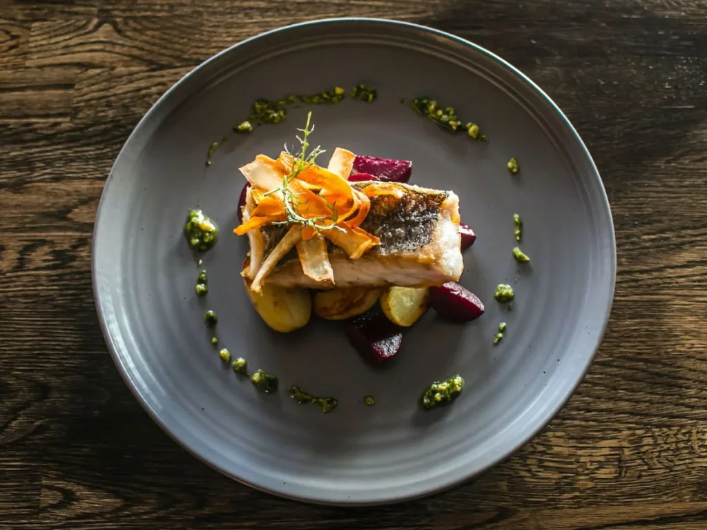 Grijs bord met mooi opgemaakt gerecht uit een restaurant