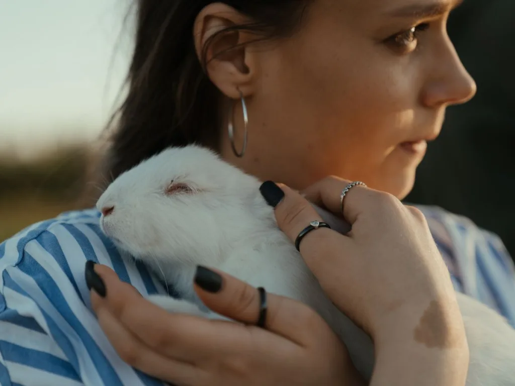 Geef jouw huisdier de beste zorg: kies voor een gespecialiseerde dierenarts - Vrouw houdt een wit konijn liefkozend vast