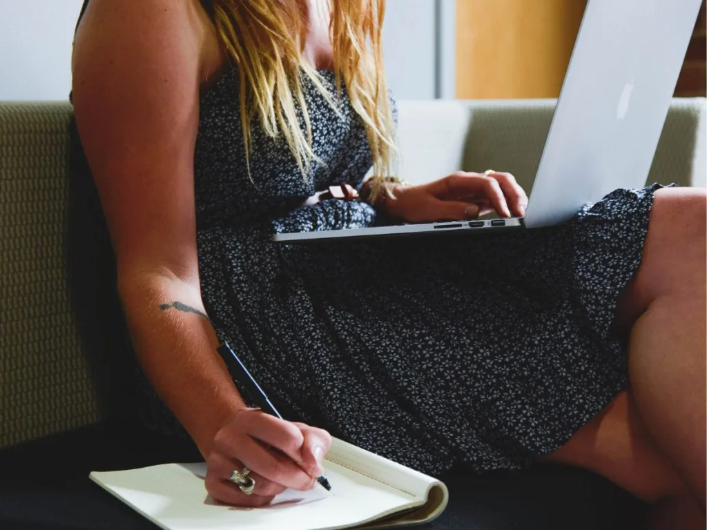 Optimaliseer je werktijd met onze 8 tips voor ondernemers - Vrouw zit te werken met laptop op schoot en notitieboek