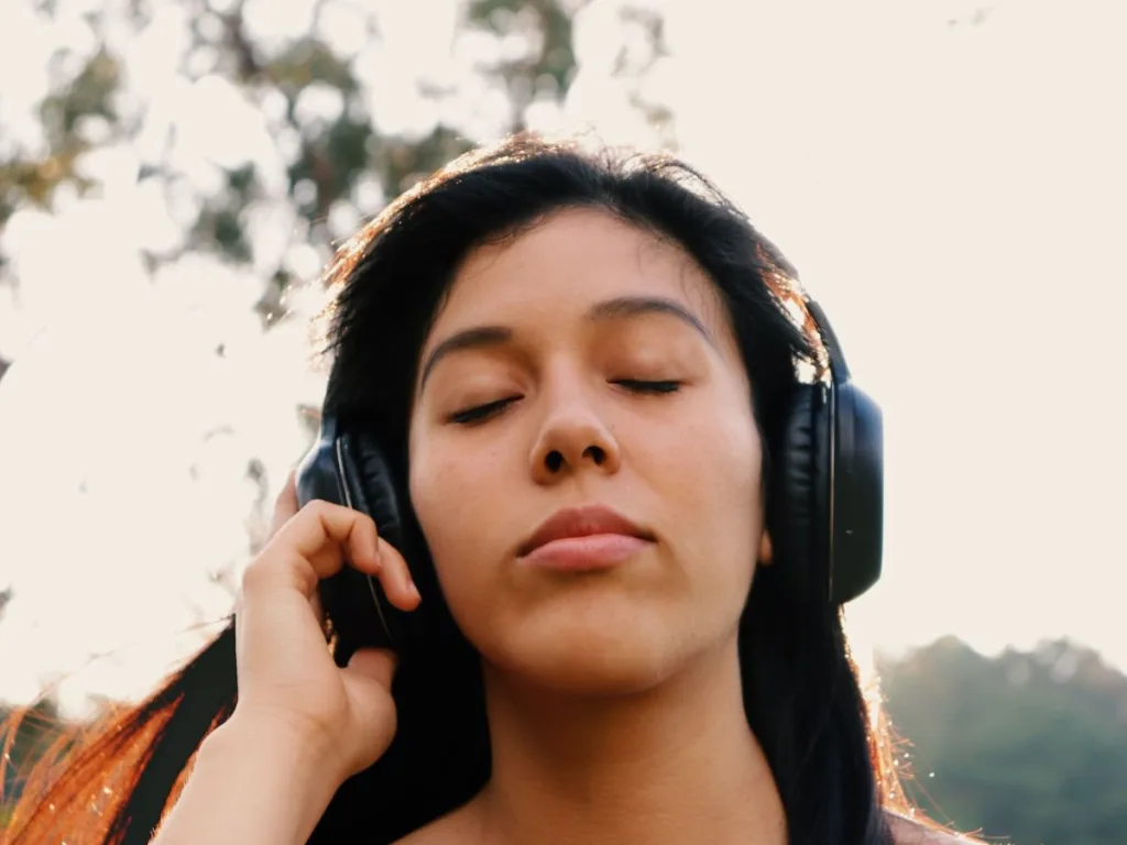 Vrouw luistert met haar ogen dicht via een koptelefoon naar focus muziek