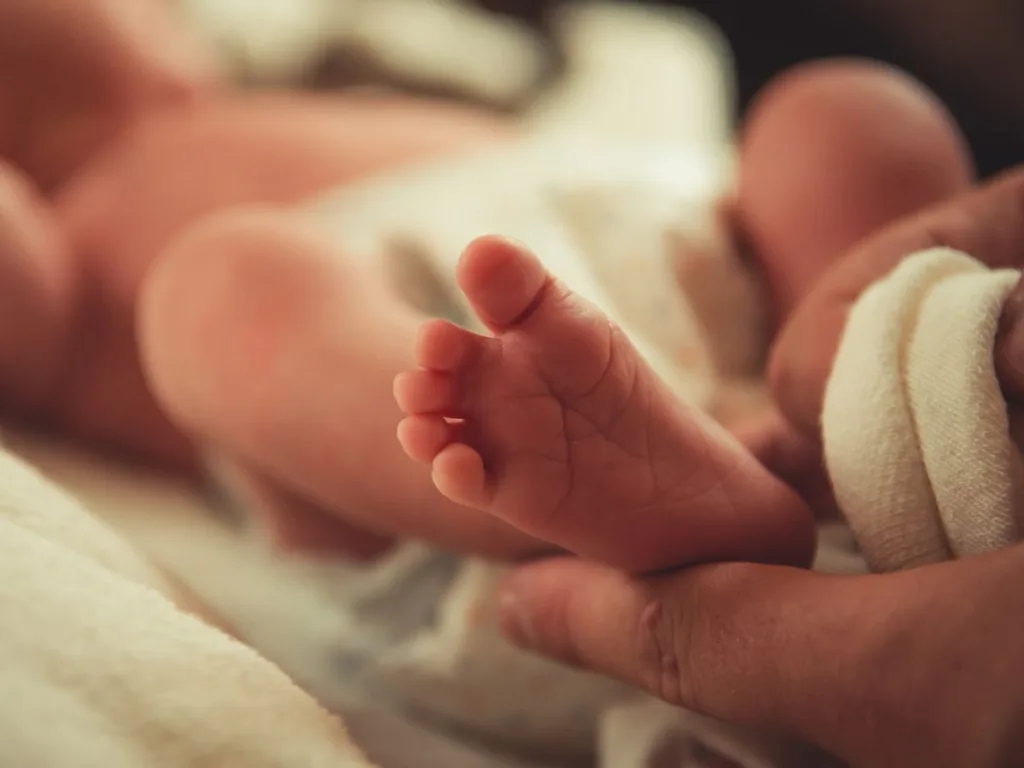 Babyvoeten in de handen van een volwassene