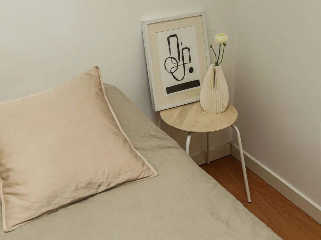 Minimalistische Japandi slaapkamer met matras en houten krukje als nachtkastje