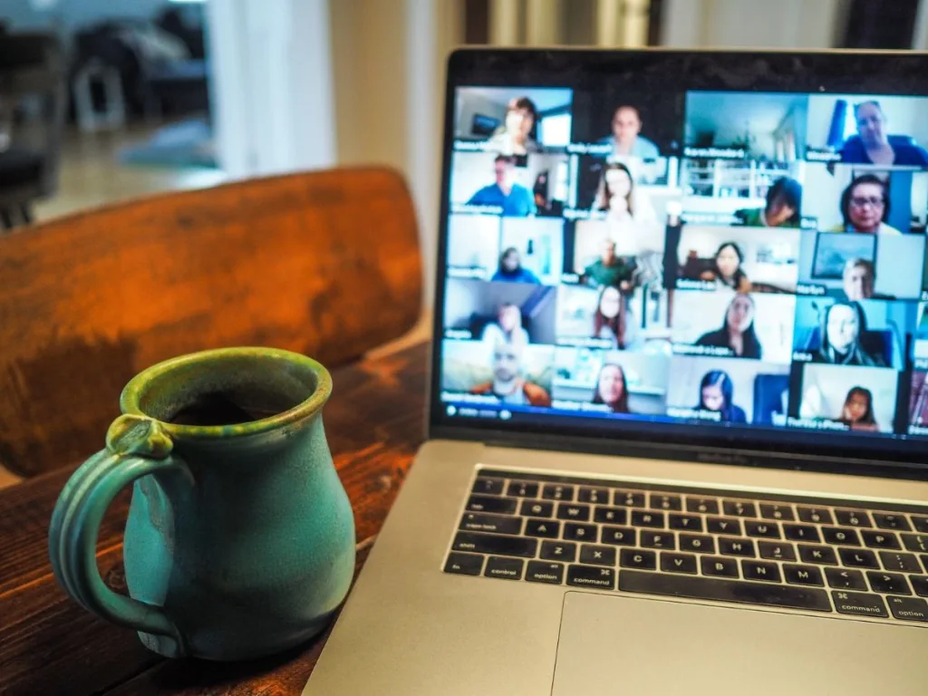 Laptop met videobel meeting op een laptop met kop drinken