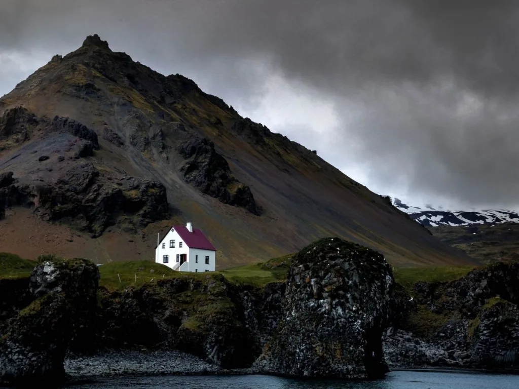 Wit huis in de donkere bergen in IJsland