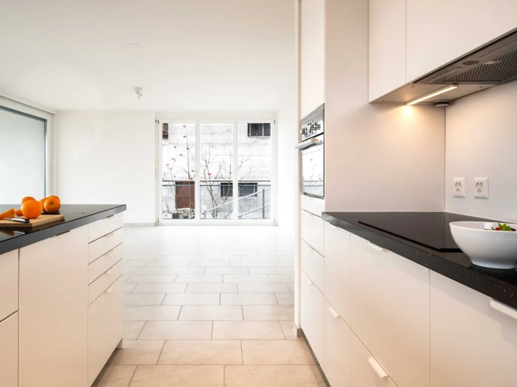 Strakke Ikea keuken met een zwart werkblad en lichte witte kastfronten