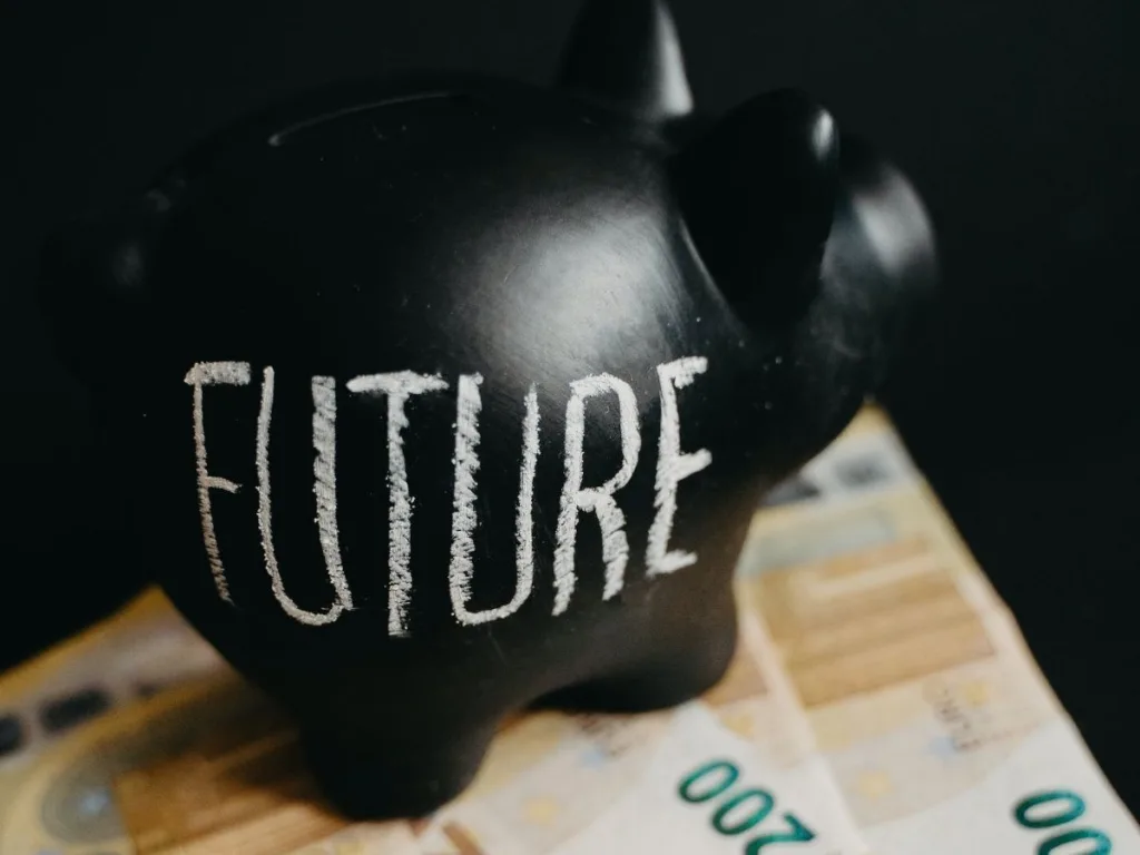 Zwart spaarvarken met de tekst toekomst op de zijkant en is gevuld met geld uit een noodfonds