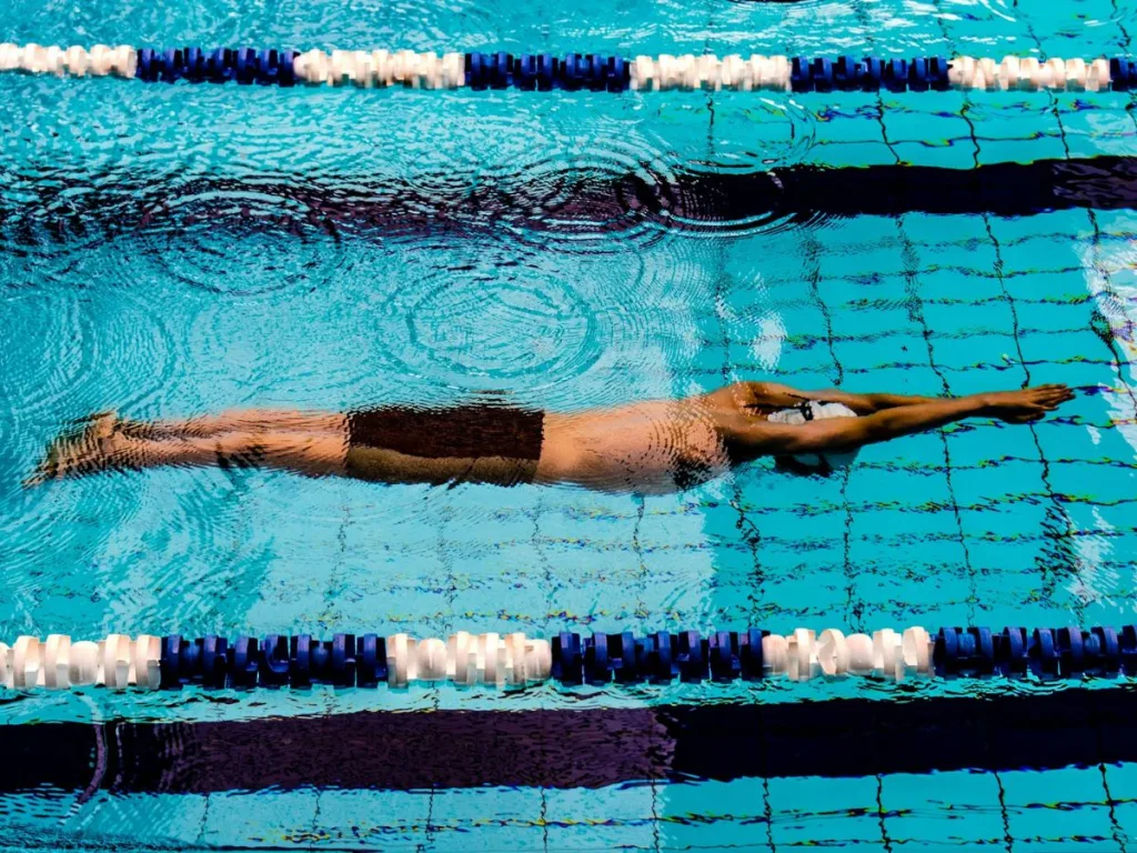 Man in een zwembad is aan het trainen door middel van zwemmen