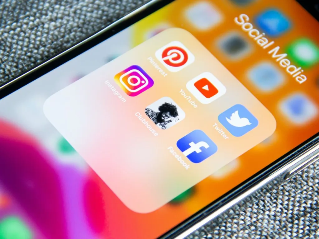 Telefoon met icoontjes van verschillende social media op het scherm