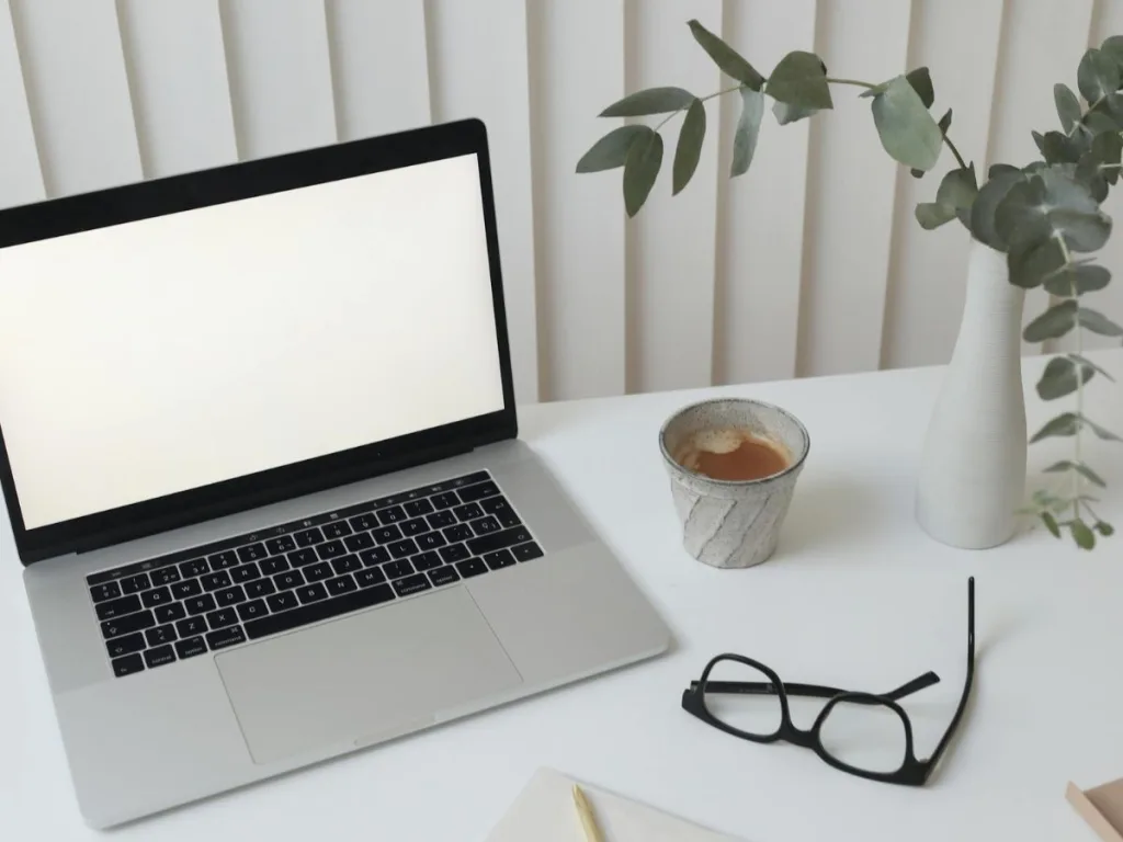 Laptop met kopje koffie en een blue filter bril